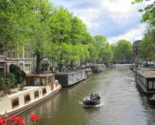 Amsterdam canal with boat and houseboats